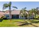 Lush backyard with mature palm trees and view of the screened in lanai at 16233 Amethyst Key Dr, Wimauma, FL 33598
