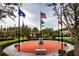 Community square displaying flags, benches, and landscaping, fostering a sense of patriotism and community at 16233 Amethyst Key Dr, Wimauma, FL 33598