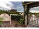 Charming community garden entrance with pergola and white picket fence, offering a serene and welcoming atmosphere at 16233 Amethyst Key Dr, Wimauma, FL 33598