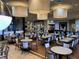 Spacious dining room with tables, chairs, and modern lighting fixtures at 16233 Amethyst Key Dr, Wimauma, FL 33598