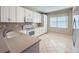 Well-lit kitchen featuring stainless steel appliances, countertops, and tile flooring for a modern aesthetic at 16233 Amethyst Key Dr, Wimauma, FL 33598