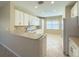 Bright kitchen features white cabinetry, stainless steel appliances, tile backsplash, and modern countertops at 16233 Amethyst Key Dr, Wimauma, FL 33598