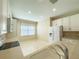 Clean kitchen with stainless steel appliances, neutral countertops, tile backsplash, and tile flooring throughout at 16233 Amethyst Key Dr, Wimauma, FL 33598