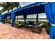 Covered outdoor patio featuring comfortable wicker seating, a coffee table, and elegant blue drapery for a cozy lake view at 16233 Amethyst Key Dr, Wimauma, FL 33598