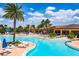 Beautiful pool area with a modern design, featuring a spacious pool deck, comfortable lounge chairs, and tropical palm trees at 16233 Amethyst Key Dr, Wimauma, FL 33598