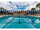 Long swimming pool featuring lane ropes and pennant-style decorations, with blue and white accents around the deck and in the sky at 16233 Amethyst Key Dr, Wimauma, FL 33598