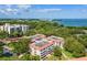 Stunning aerial view of a condo complex surrounded by lush trees with waterfront views and community landscaping at 2650 Pearce Dr # 403, Clearwater, FL 33764