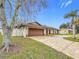 Single-story home with a brown garage door and brick accents at 1557 Jeffords St, Clearwater, FL 33756