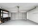 Garage with grey floor, storage shelves, and an automatic garage door at 1557 Jeffords St, Clearwater, FL 33756