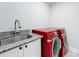 Clean laundry room featuring a granite countertop sink and red appliances at 1557 Jeffords St, Clearwater, FL 33756