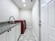 Bright laundry room with white cabinets, granite countertop, and red washer and dryer at 1557 Jeffords St, Clearwater, FL 33756