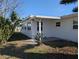 Exterior view showing a white home, lawn, with lush tropical landscaping and a covered patio at 4415 96Th N Ave, Pinellas Park, FL 33782