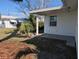 Side view of the home, showing the back porch and backyard with tropical plants at 4415 96Th N Ave, Pinellas Park, FL 33782