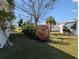 Well-maintained lawn with lush landscaping including a red flowering bush, and tropical palm at 4415 96Th N Ave, Pinellas Park, FL 33782