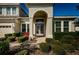 Inviting home entrance with brick pathway, arched doorway, and lush landscaping at 8319 Swiss Chard Cir, Land O Lakes, FL 34637