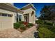 Charming home exterior featuring a well-manicured lawn and brick pathway to the front door at 8319 Swiss Chard Cir, Land O Lakes, FL 34637