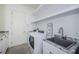 Clean laundry room featuring washer, dryer, shelving, sink and counterspace at 8319 Swiss Chard Cir, Land O Lakes, FL 34637