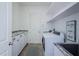 Well-lit laundry room with modern washer and dryer, granite countertop, and storage cabinets at 8319 Swiss Chard Cir, Land O Lakes, FL 34637