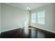 Bright, naturally lit living room with hardwood floors and contemporary light fixture at 8319 Swiss Chard Cir, Land O Lakes, FL 34637