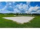 A sand volleyball court in a community park with a volleyball net and lush green grass at 8319 Swiss Chard Cir, Land O Lakes, FL 34637