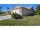 Side view of the two-car garage showing maintained lawn and corner landscaping at 8949 Bay Pointe Ct, Hudson, FL 34667