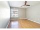 Bright bedroom features wood-look floors, a ceiling fan, and a large window at 13608 S Village Dr # 6203, Tampa, FL 33618