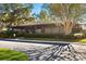 Exterior of the community clubhouse featuring mature trees and landscaping at 13608 S Village Dr # 6203, Tampa, FL 33618