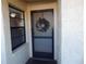 Condo entrance with screen door and holiday wreath at 14130 Rosemary Ln # 2102, Largo, FL 33774