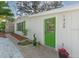 White house exterior with a bright green front door and landscaped walkway at 1428 Illinois Ave, Palm Harbor, FL 34683