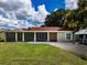 House exterior featuring a green house with a red roof and spacious lawn at 11224 Inglewood Dr, Gibsonton, FL 33534