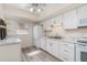 Galley kitchen featuring white cabinets, stainless steel appliances, and marble countertops at 5110 28Th W St, Bradenton, FL 34207