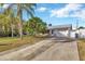 House exterior with driveway, landscaping, and metal roof at 6598 26Th N St, St Petersburg, FL 33702