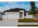 Modern house with white exterior, black roof, and a two-car garage at 2513 W Hiawatha St, Tampa, FL 33614