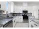 Modern kitchen with white cabinets, gray countertops, and stainless steel appliances at 2513 W Hiawatha St, Tampa, FL 33614