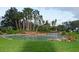 Relaxing pool with a waterfall feature and a tropical landscaped area, framed by lush grass at 5011 Sandy Brook Cir, Wimauma, FL 33598