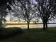 Beautiful water view at sunset with trees silhouetted against the colorful sky at 5011 Sandy Brook Cir, Wimauma, FL 33598