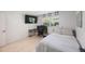 Bedroom featuring a light wood-look floor, neutral paint, and a functional desk setup at 1753 Belleair Forest Dr # E2, Belleair, FL 33756