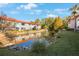 Exterior view of condos nestled by pond with fountain and lush landscaping at 1753 Belleair Forest Dr # E2, Belleair, FL 33756