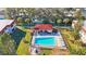 Aerial view of the community pool with lounge chairs and a shaded cabana, surrounded by lush landscaping at 1753 Belleair Forest Dr # E2, Belleair, FL 33756