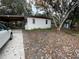 Front view of a white house with a carport and yard at 432 2Nd Ne Ave, Largo, FL 33770