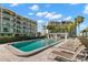 Community pool with lounge chairs and surrounding buildings at 9815 Harrell Ave # 301, Treasure Island, FL 33706