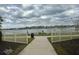 Peaceful walkway with lake views and white fence at 18843 Ulmus St, Lutz, FL 33558