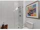 Bathroom with a shower, toilet and modern artwork at 5316 Loon Nest Ct, Apollo Beach, FL 33572