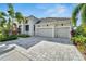 Gray house with three-car garage and a paved driveway at 5316 Loon Nest Ct, Apollo Beach, FL 33572