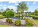Serene pond with bench seating and tropical landscaping at 34 Concord Dr, Dunedin, FL 34698