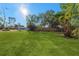 Large grassy backyard with mature trees and a partially visible fence at 5100 3Rd S Ave, St Petersburg, FL 33707
