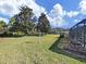 Expansive backyard featuring lush greenery, mature trees, and a screened lanai at 11213 Warm Wind Way, Weeki Wachee, FL 34613