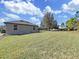 Large backyard with well-maintained green grass and mature trees offer relaxing, quiet enjoyment at 11213 Warm Wind Way, Weeki Wachee, FL 34613