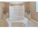 Bathroom showcasing a large soaking tub with tiled surround and sleek fixtures, offering a spa-like retreat at 11213 Warm Wind Way, Weeki Wachee, FL 34613
