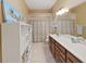 Bright bathroom features a double vanity, linen closet and tiled shower/tub at 11213 Warm Wind Way, Weeki Wachee, FL 34613